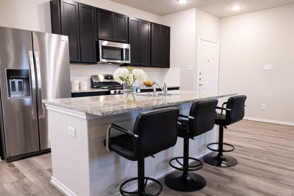 black bar stool at an island in a kitchen with granite counter tops