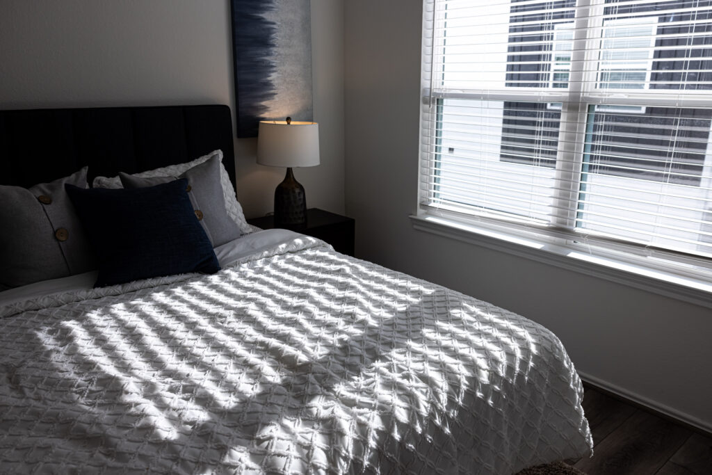 white bedsheets made in a bed with black pillow