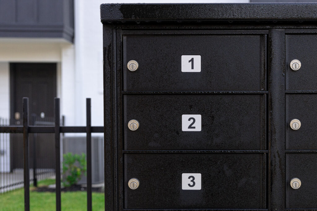 black mailbox with multiple slots outside