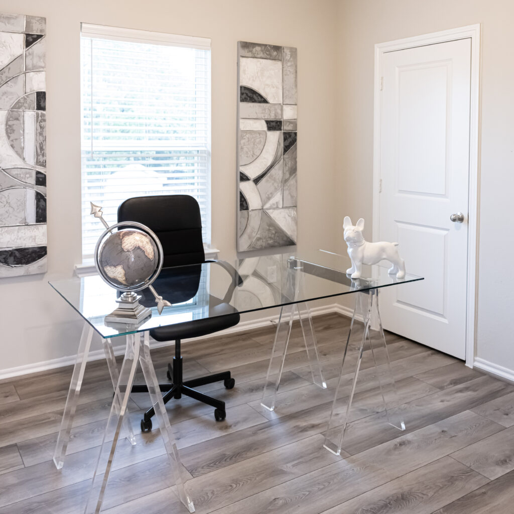 office space with see through glass desk and dark wood floors