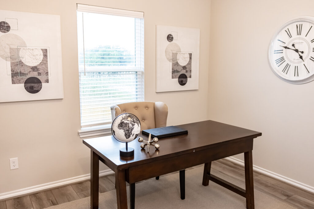 room with white walls and dark brown office desk