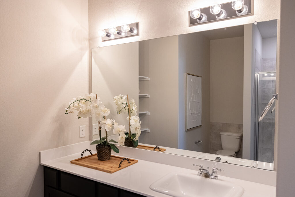 white counter sink in a bathroom with vanity lights