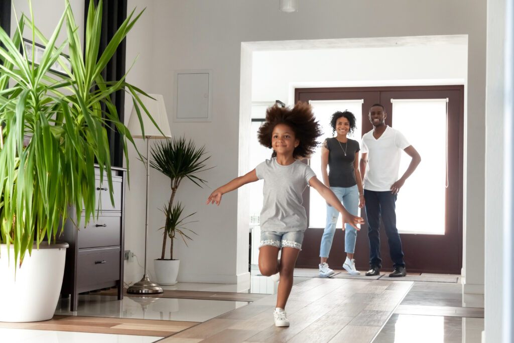 niña corriendo sonriente en su nueva casa familiar