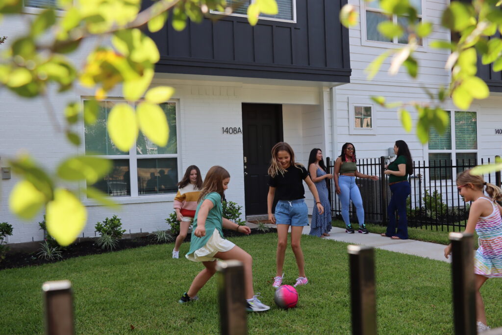 niños jugando con una pelota en un barrio de Houston Texas