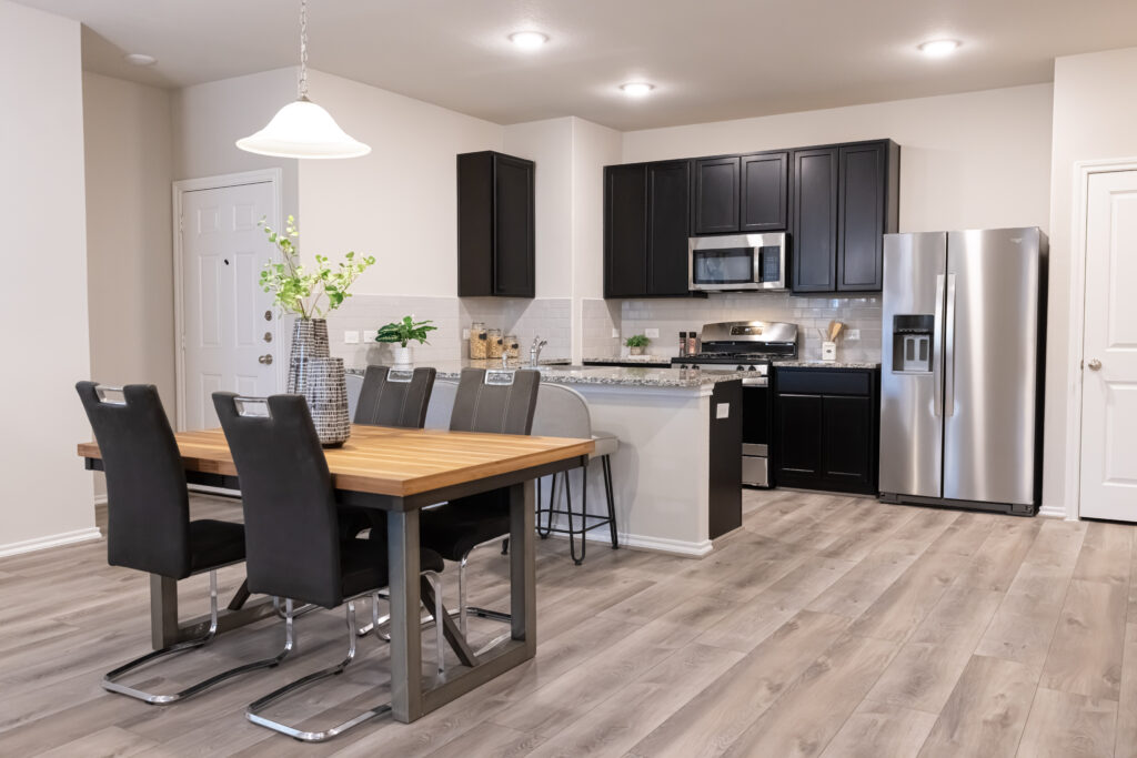 moderno comedor con suelos laminados de madera marrón y electrodomésticos de acero inoxidable