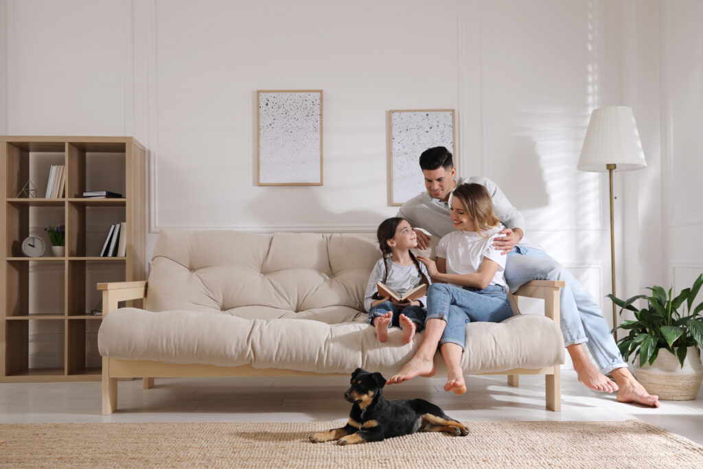 Familia feliz en el sofá y cachorro en el salón