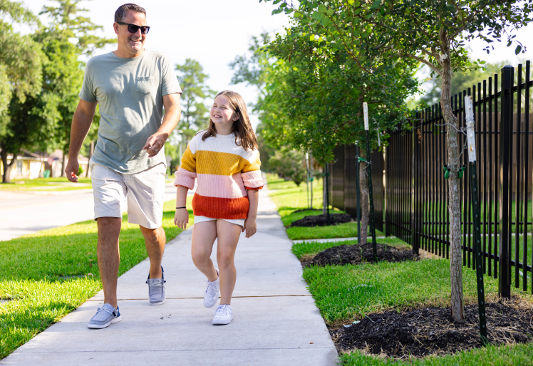 Father and Daughter Walking Down The Road Together In Houston, TX