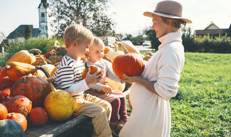 Mother and children looking at pumpkins